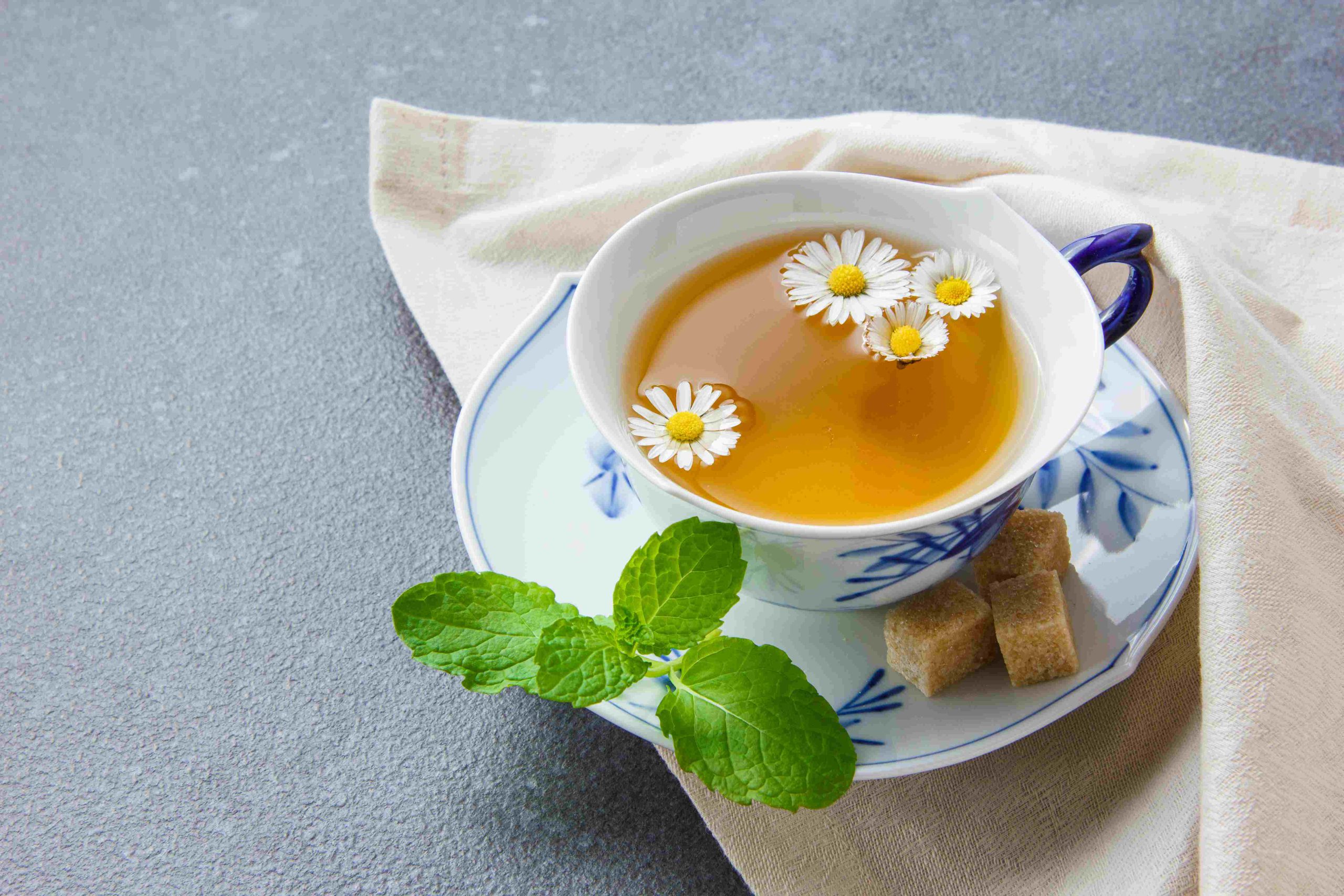 cup-chamomile-tea-with-sugar-cubes-leaves-high-angle-view-cloth